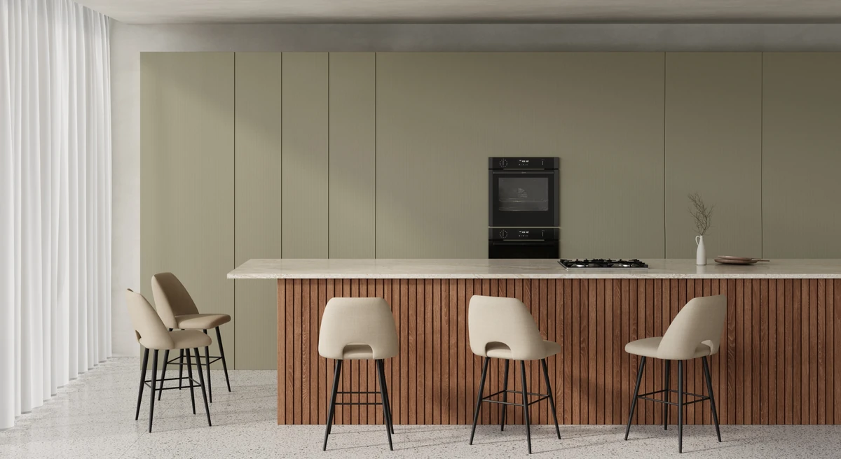 Two light-wood bar stools at a breakfast bar with metro-style tiles typical of European city kitchens