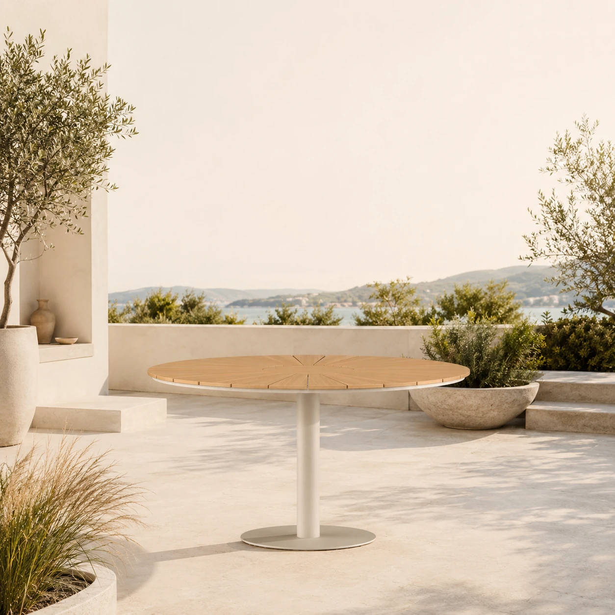 Ovaler FSC-Teak-Gartentisch mit zentraler Aluminiumsäule auf einer mediterranen Steinterrasse